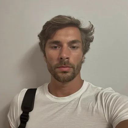 An ordinary phone selfie of a man in a plain t-shirt against a grey wall